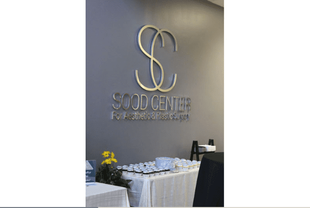 Sood Center Logo on Wall with Food Table Beneath it