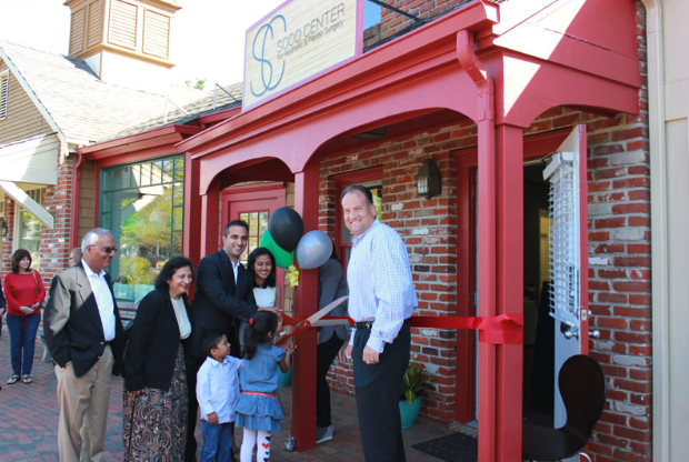 Dr. Sood Cutting Ceremonial Ribbon with Family and Guests at Opening Event