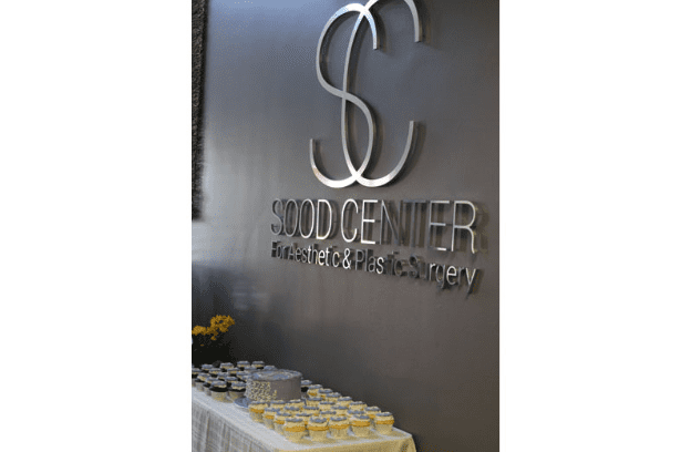 Cupcakes and Cake Set up Under the Sood Center Logo on the Wall